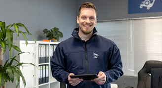 Smiling employee in a branch, tablet PC in hand.
